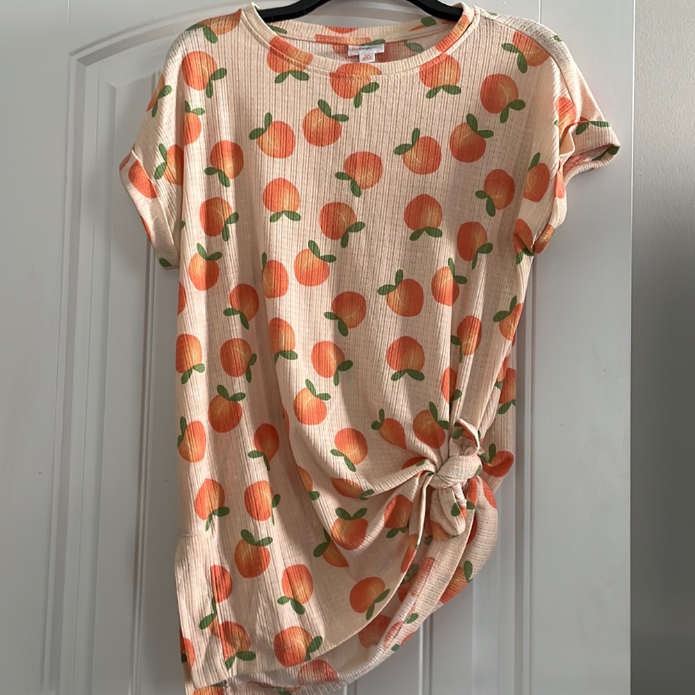 Peachy tee! Size XS but fits like a medium!!!Cute print! Pale orange color.